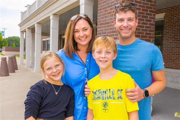 family smiling in front of CSES